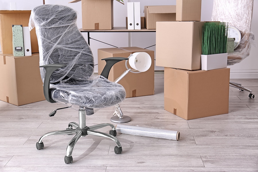 Armchair and carton boxes with stuff in room.